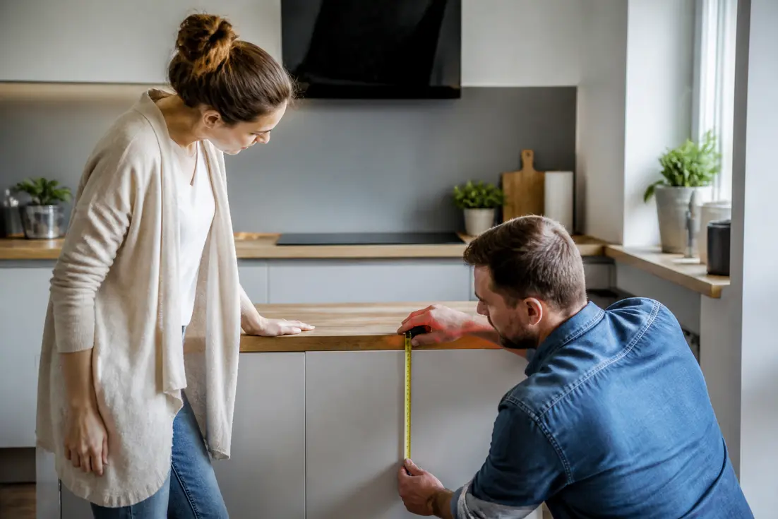 Un couple ajuste la hauteur plan de travail cuisine lors de leur rénovation intérieure