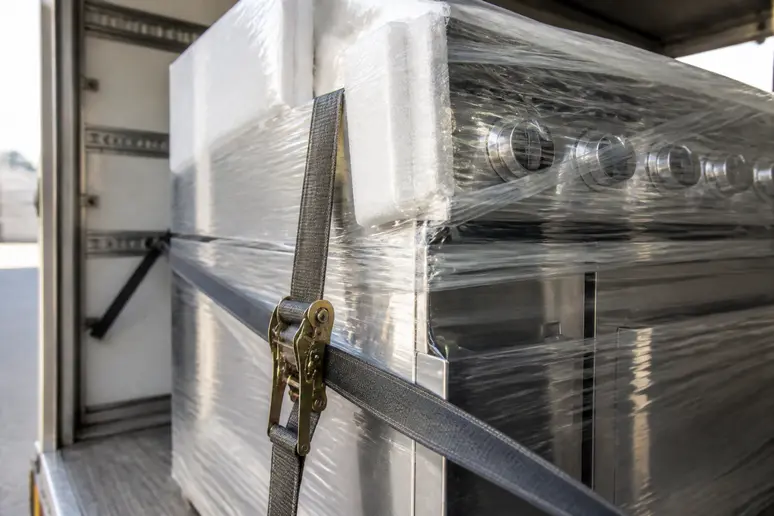 Mise en place de protections sur un meuble inox pour un transport sécurisé cuisine industrielle.