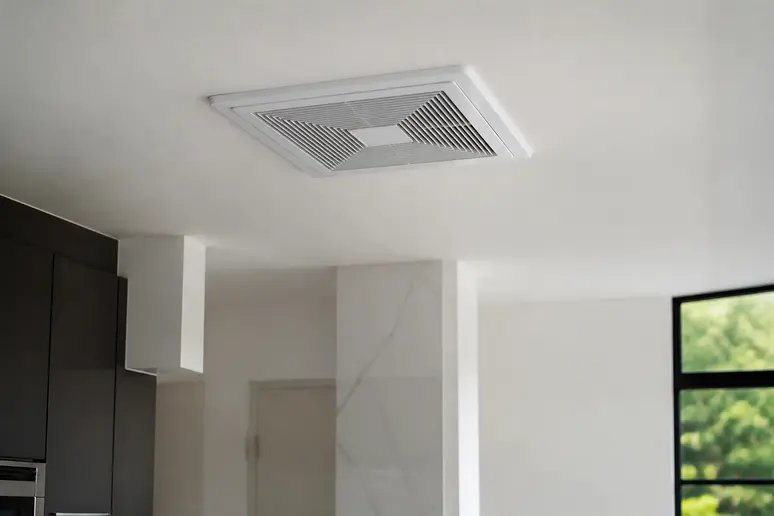 Bouche d'extraction VMC installée au plafond d'une cuisine pour assurer la ventilation.