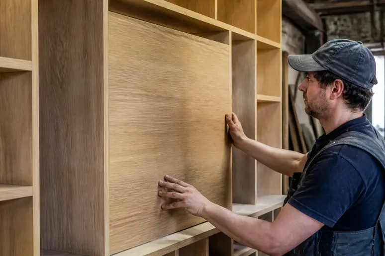 Détail de fabrication d'un meuble TV bibliothèque sur-mesure en bois avec finitions soignées